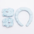 Set of light blue hair accessories including scrunchies and a headband on a white background.