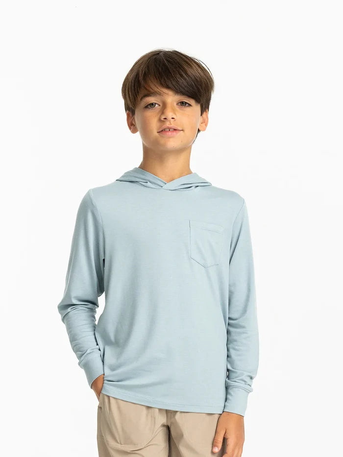 Child wearing a light blue hoodie on a white background