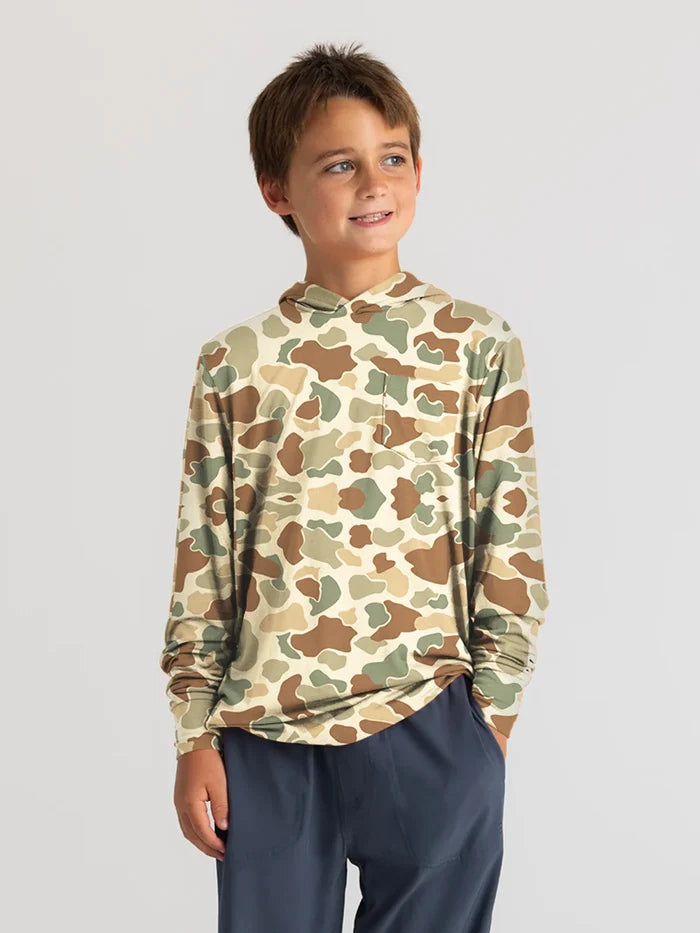 A boy wearing a long-sleeved blue hoodie with a fitted hood and a left-chest pocket, standing against a white background.