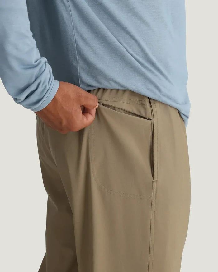 Person wearing beige pants and a light blue shirt on a plain background
