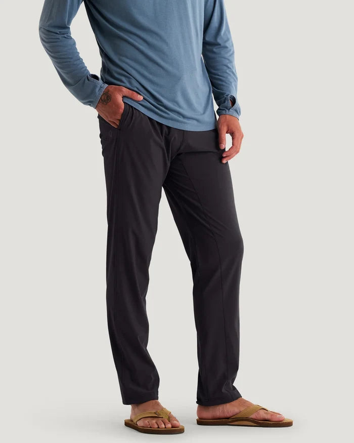 Person wearing a blue long-sleeve shirt and black pants on a plain background