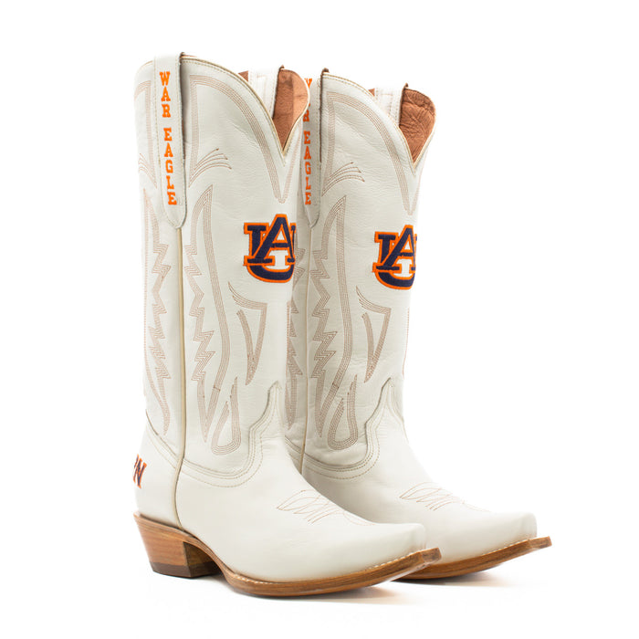 A pair of white women's western boots with embroidered team logos and a wood heel, designed for gameday attire.