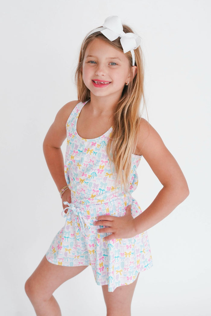 Young girl wearing a floral romper with a white background