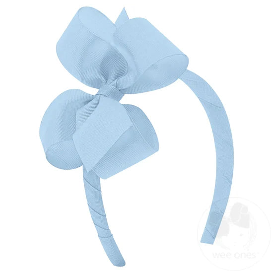 Blue bow and headband combo on a white background.