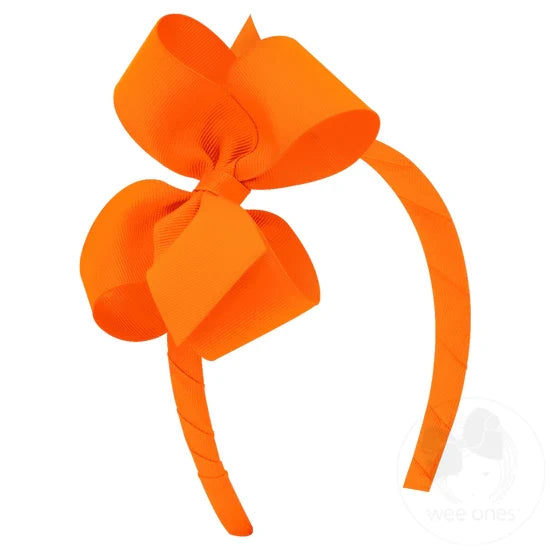 Orange bow and headband combo on a white background.