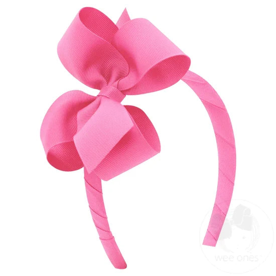 Pink bow and headband combo on a white background.