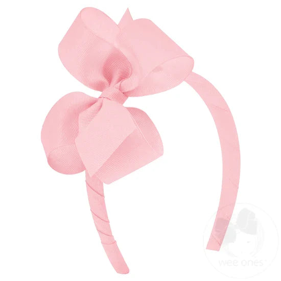 Pink bow and headband combo on a white background.