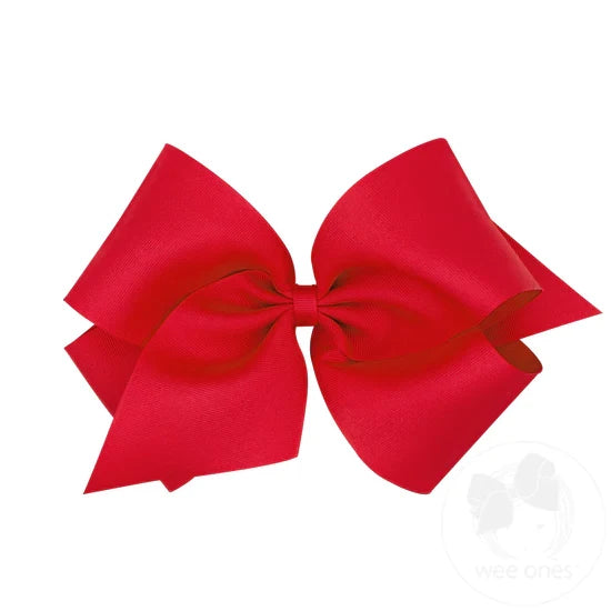 A red hair bow with a grosgrain ribbon and a knot in the center.