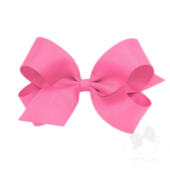 A large pink grosgrain ribbon hair bow attached to a clip.