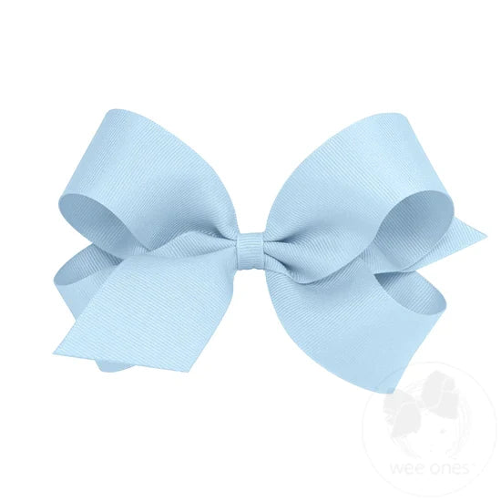 A large blue grosgrain ribbon hair bow attached to a clip.