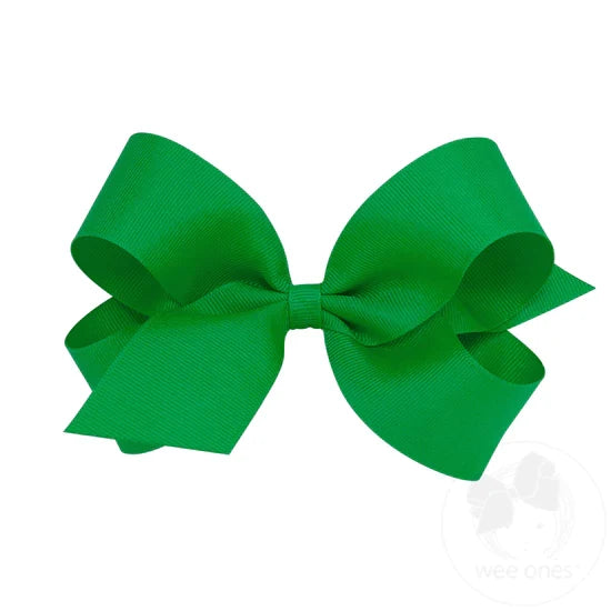 A large green grosgrain ribbon hair bow attached to a clip.