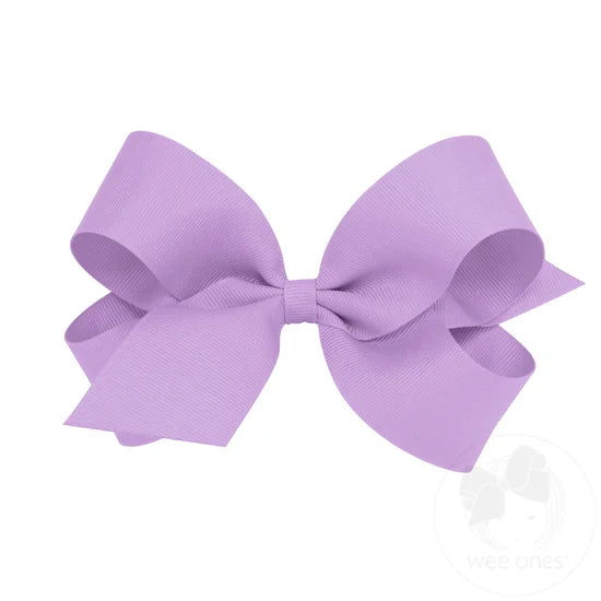 A large purple grosgrain ribbon hair bow attached to a clip.