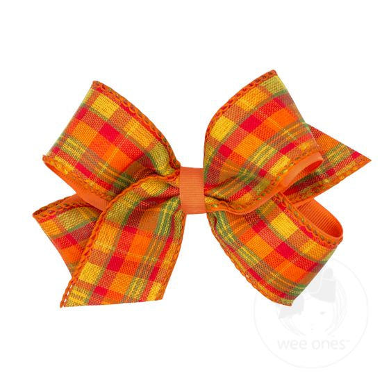 Plaid bow with orange, red, and green colors on a white background