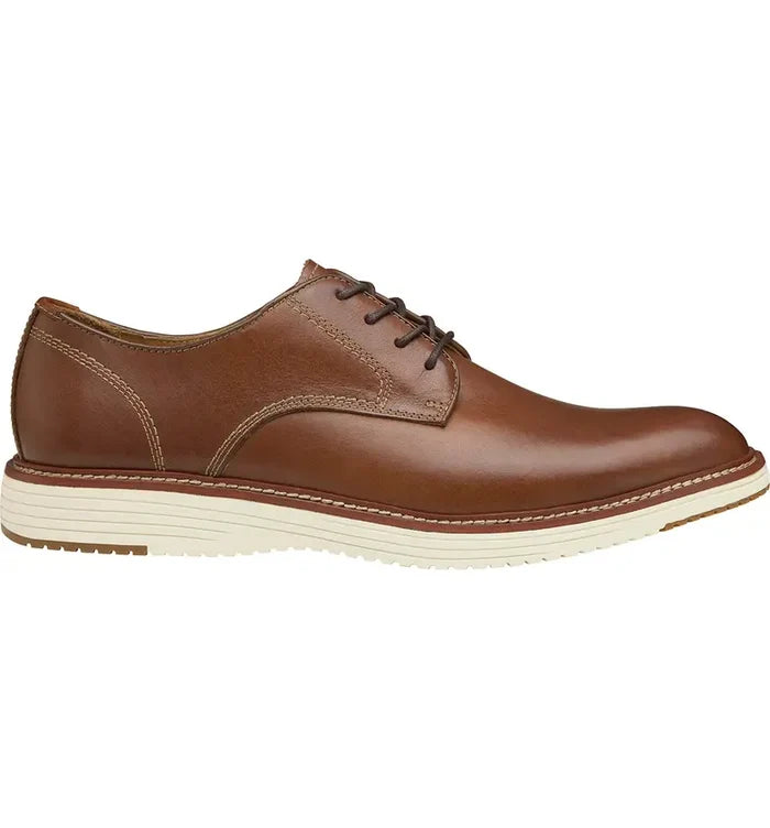 A brown Johnston & Murphy Upton Plain Toe Shoe with a white sole.
