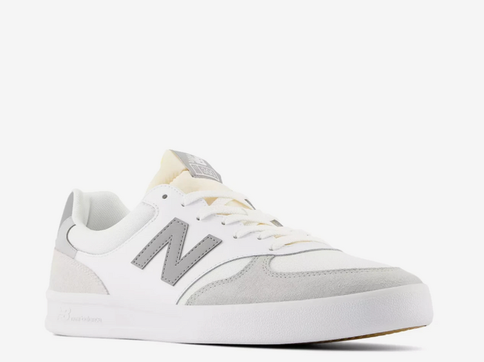 A pair of New Balance CT300 sneakers with a white mesh fabric, leather & suede upper, and a rubber sole.