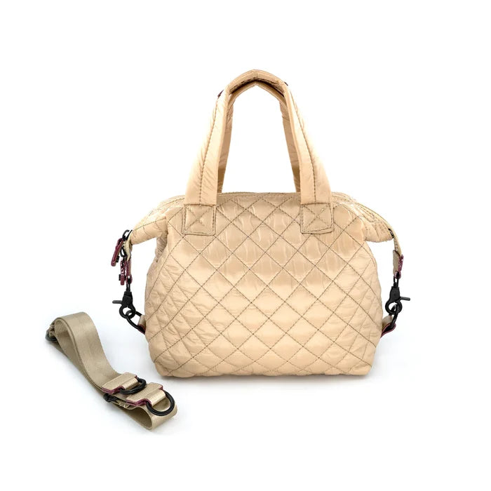 A quilted beige crossbody bag with a removable strap, displayed against a plain background.