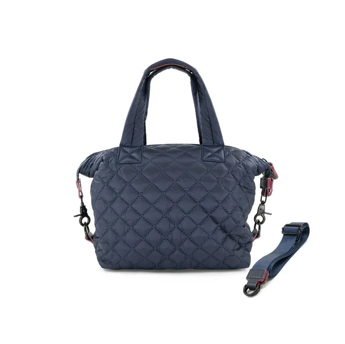 A quilted navy crossbody bag with a removable strap, displayed against a plain background.