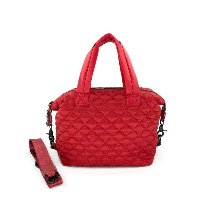 A quilted red crossbody bag with a removable strap, displayed against a plain background.