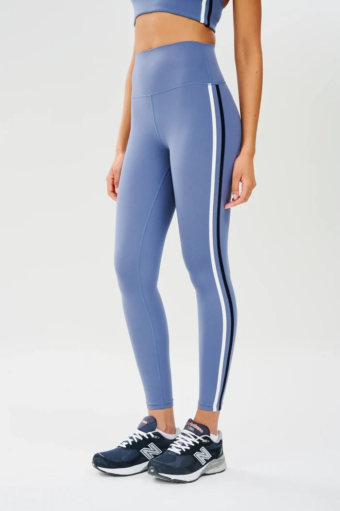 A pair of high-waisted black leggings with white double stripes on the side, intended to sit above the ankle in length.