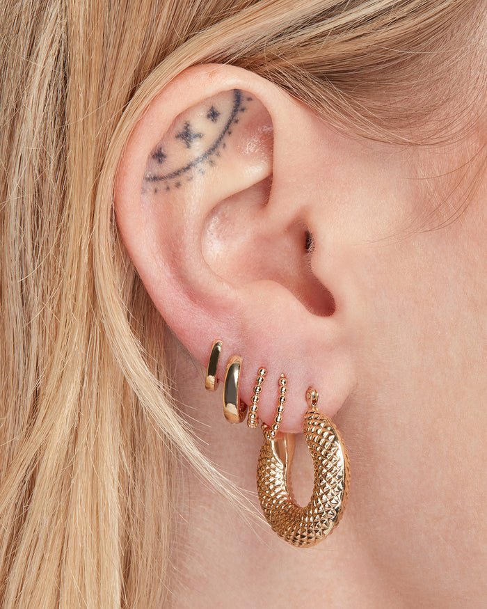 The Mini 14K Beaded Huggies are the second and third hoop in the earring stack