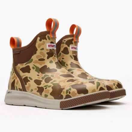 Camouflage-patterned boots with orange accents on a white background