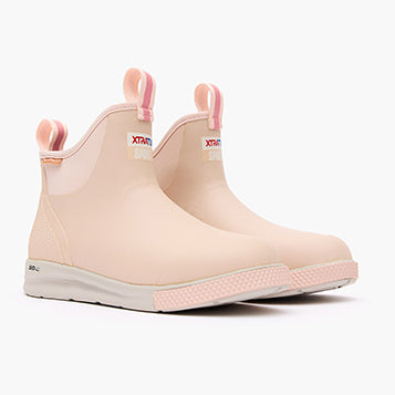 Pair of pink rain boots with white soles on a white background
