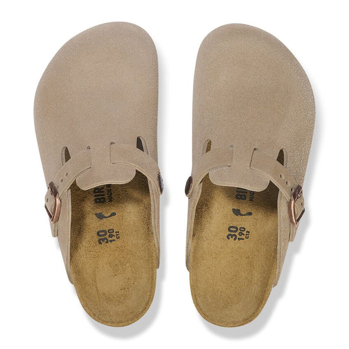 Beige clog shoe with a strap and buckle on a white background