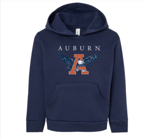 Youth wearing a white hoodie with 'AUBURN' text and a logo on the front standing against a brick wall.